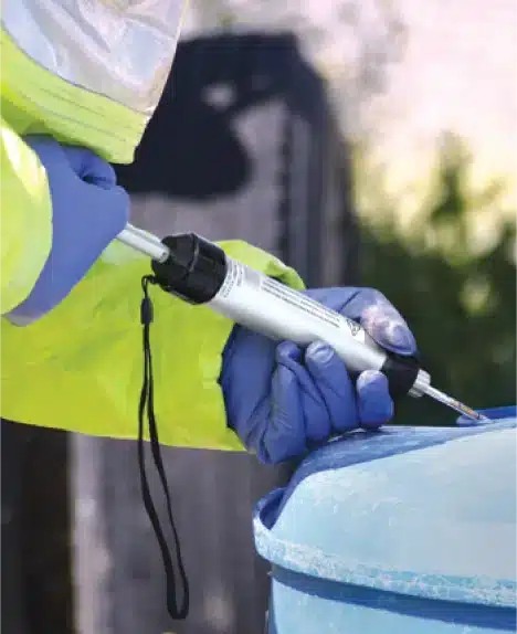 Un secouriste utilise des tubes colorimétriques et une pompe manuelle de RAE Systems pour mesurer les niveaux de COV à l'intérieur d'un tonneau.